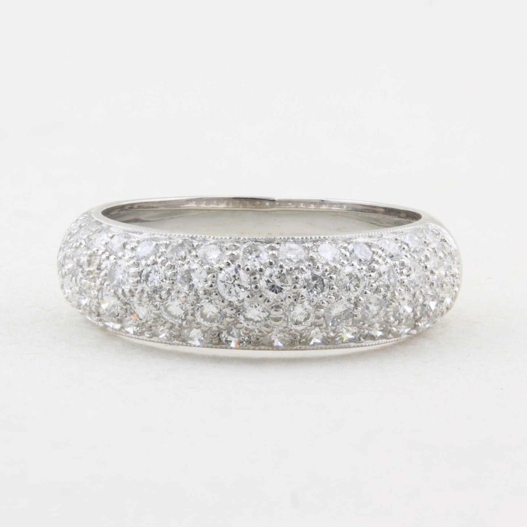 A ring paved with diamonds, photographed on a plain light background.