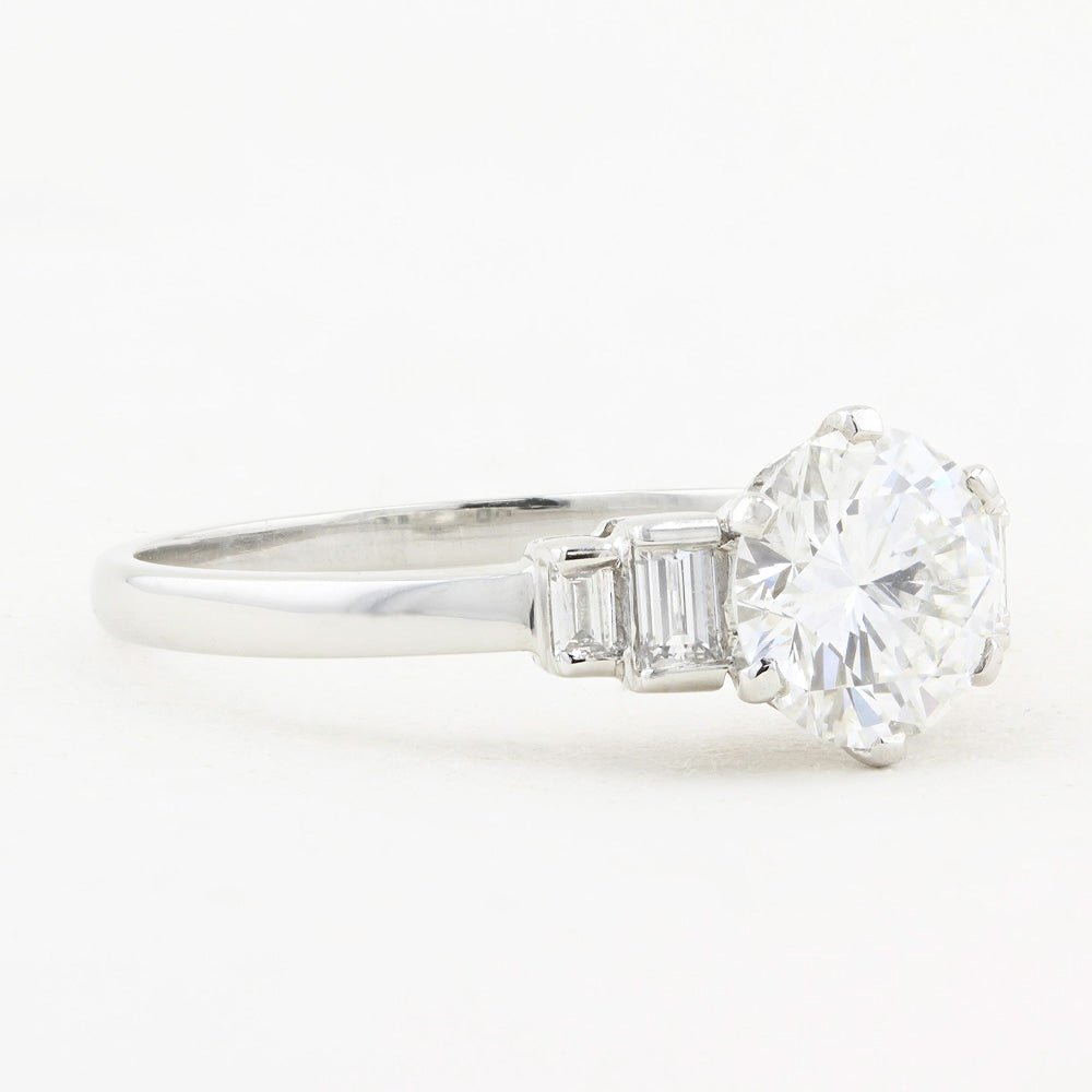 Diamond ring with a 1.12ct central diamond and tapered baguette-cut diamonds on a white background