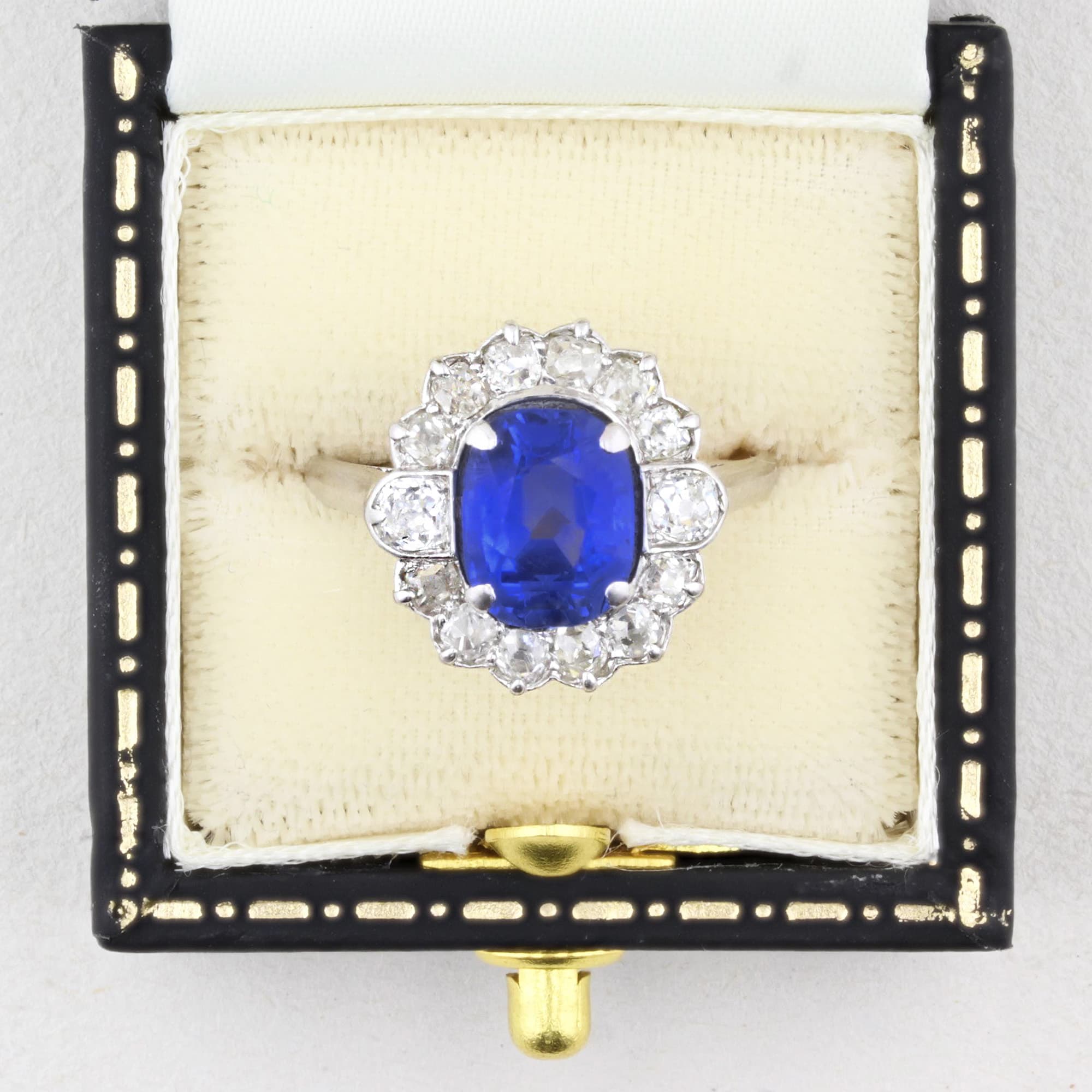 Vintage jewellery box with a ring featuring a blue sapphire and diamond accents.