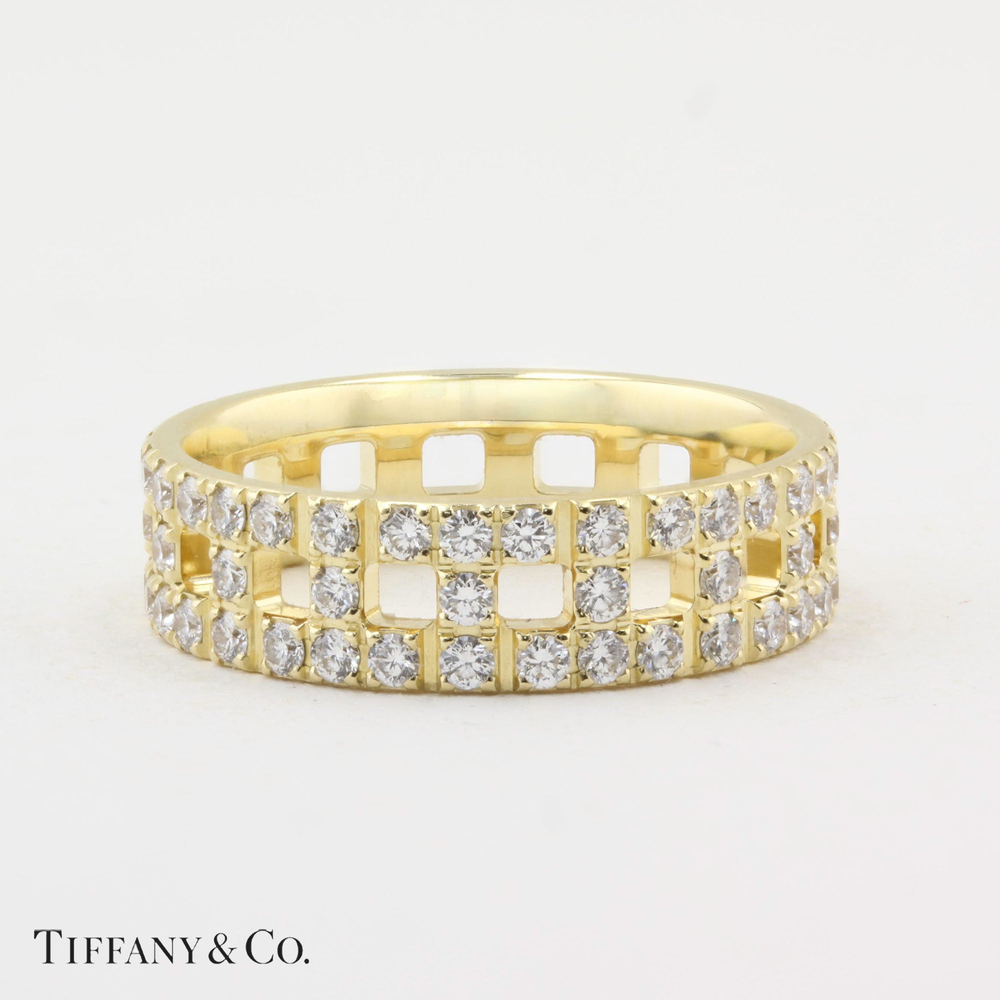 Gold ring with diamond accents on a white background, featuring the Tiffany &amp; Co. logo.
