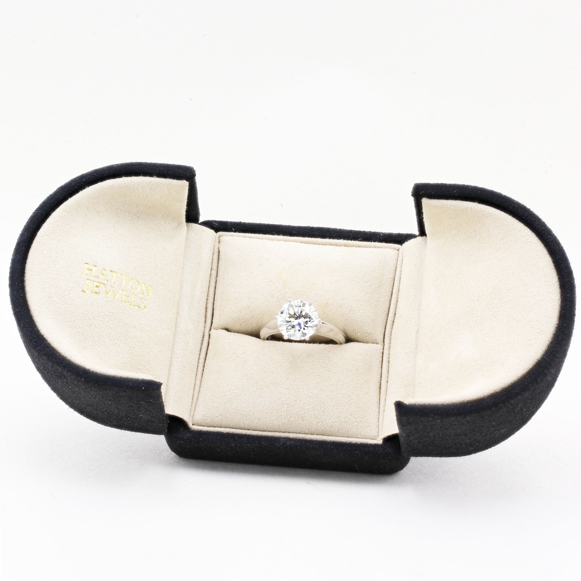 Diamond ring in a black and beige jewellery box on a white background