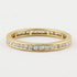 A yellow gold eternity ring featuring a continuous channel setting of round-cut diamonds on a plain white background.