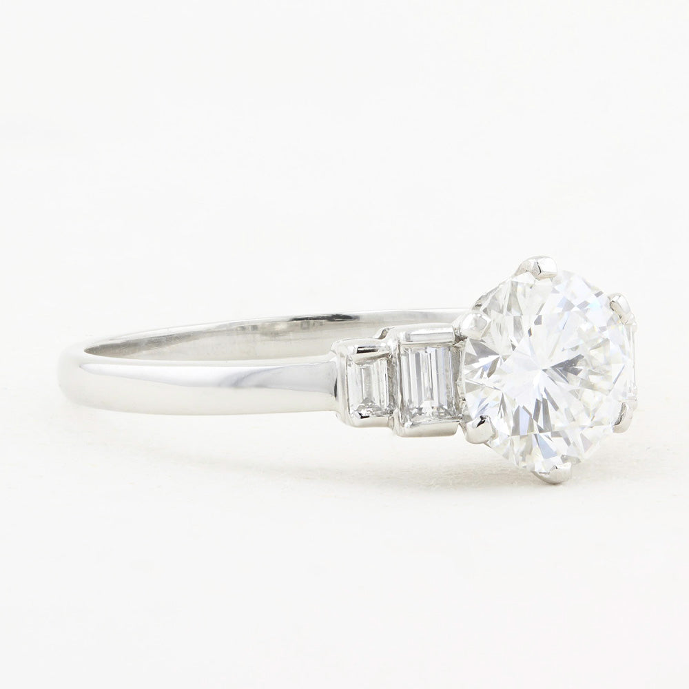 Diamond ring with a 1.12ct central diamond and tapered baguette-cut diamonds on a white background