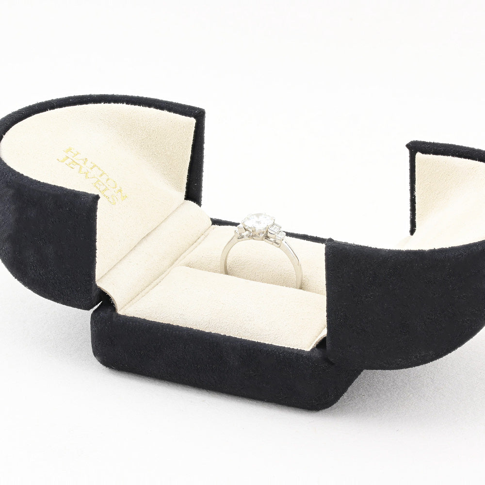 Black jewellery box with a ring inside on a white background